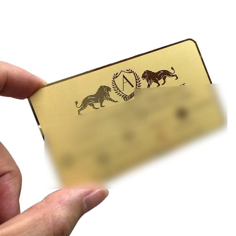 Brushed gold card with engraved lion artwork; contact details blurred